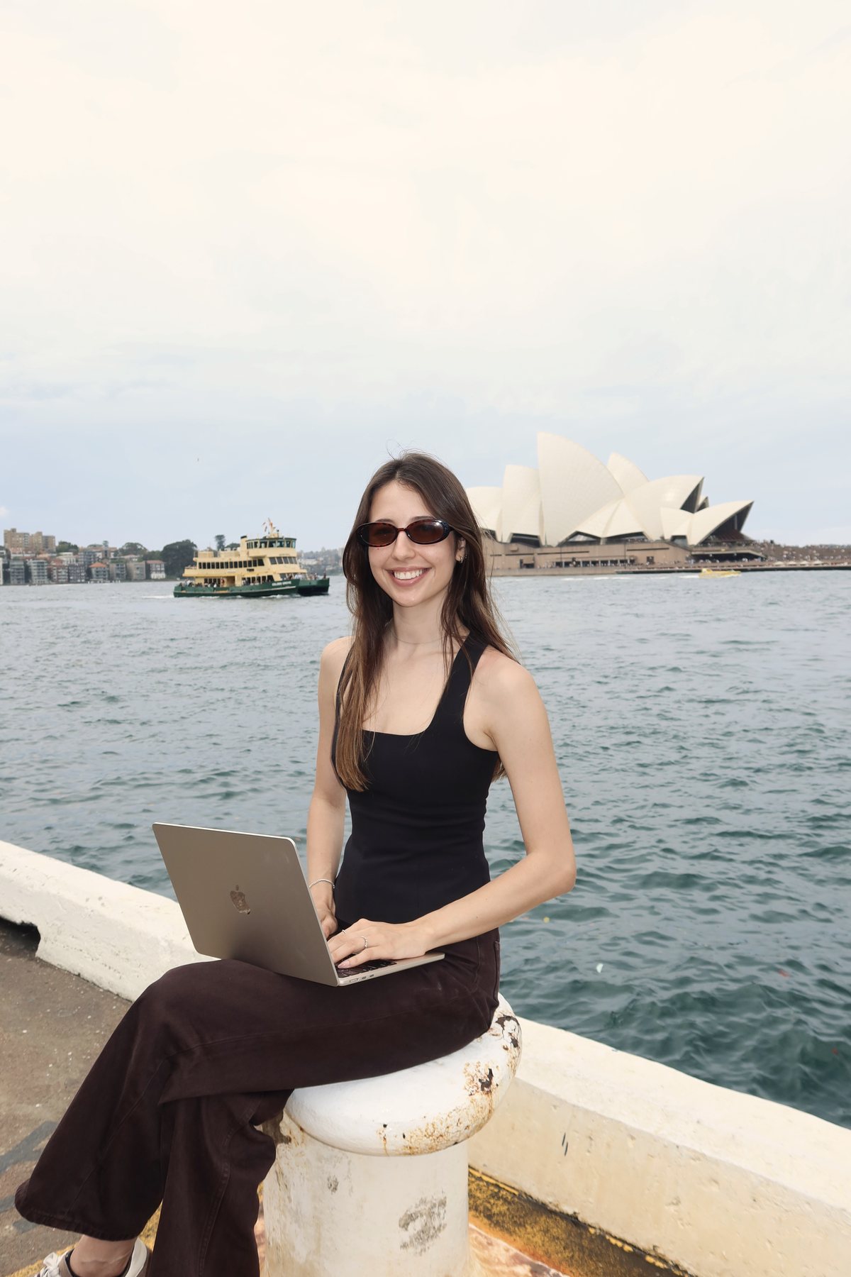 Luiza working on a laptop on a Sydney ferry